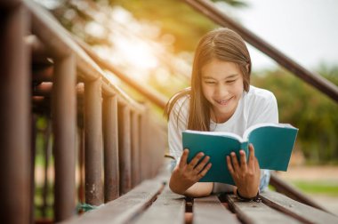 Amfitiyatroda elinde bir kitapla uzanan güzel esmer kadın. Romantik açık hava kavramı.