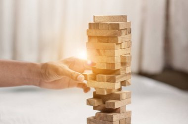 Modern ofisteki kuleye el çekmek ya da tahta bloğu yerleştirmek. Plan ve iş stratejisi. Arkaplan için bulanık.