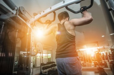 Spor salonunda egzersiz yapan kaslı genç adam, sırt egzersizi yapan vücut geliştirici..