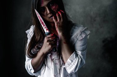 Karanlıkta elinde kanlı bir bıçakla Hayalet kadın portresi. Kâbus, cehennem korkusu Cadılar Bayramı festivalinde canavar şeytandır, uzayı doğru şekilde kopyalayın..