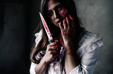 Karanlıkta elinde kanlı bir bıçakla Hayalet kadın portresi. Kâbus, cehennem korkusu Cadılar Bayramı festivalinde canavar şeytandır, uzayı doğru şekilde kopyalayın..