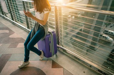 Kadınlar havaalanlarındaki uçuş kontrollerinde akıllı telefonlarını kullanıyorlar. Havaalanları ve teknoloji konsepti