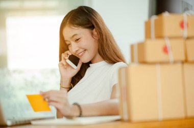 Güzel kadın sahibi iş kadını online alışveriş için evde çalışıyor. İnternet iş konsepti.