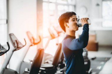 Spor salonunda protein içen fitness adamı. Spor, spor, sağlıklı yaşam tarzı ve insanlar konsepti.