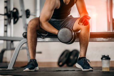 Vücut geliştirici, spor salonundaki halter ağırlıklarıyla çalışıyor. Halterle egzersiz yapıyor. Fitness kaslı vücut 