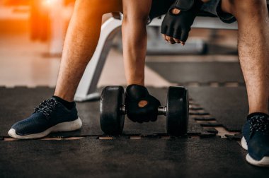 Vücut geliştirici, spor salonundaki halter ağırlıklarıyla çalışıyor. Halterle egzersiz yapıyor. Fitness kaslı vücut 
