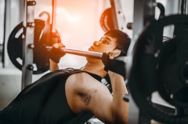 Bench Press Egzersizi. Sert atletik bir adam göğüs baskısında kaslarını şişiriyor. Sağlıklı yaşam tarzı kavramı. Spor salonunda çapraz vücut geliştirici..