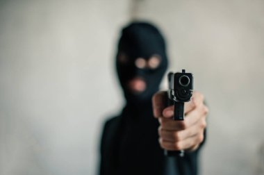 Silahlı bir soyguncu gözdağı veriyor. Suç ve soygun kavramı..