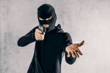 Silahlı bir soyguncu gözdağı veriyor. Suç ve soygun kavramı..