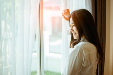 Asyalı kadın sabah uyanıyor, mutlu ve zinde.