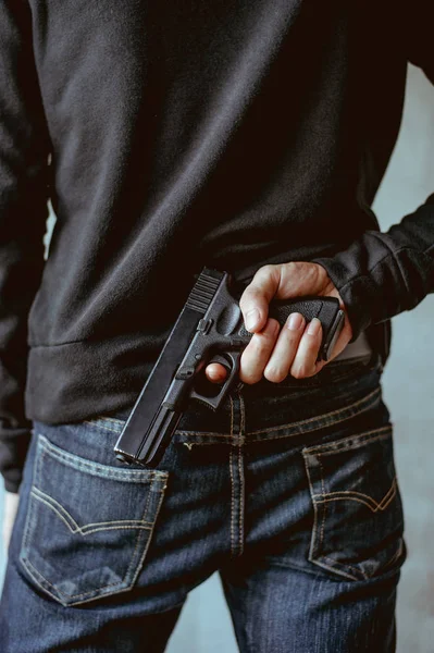 A man holding a gun on his back