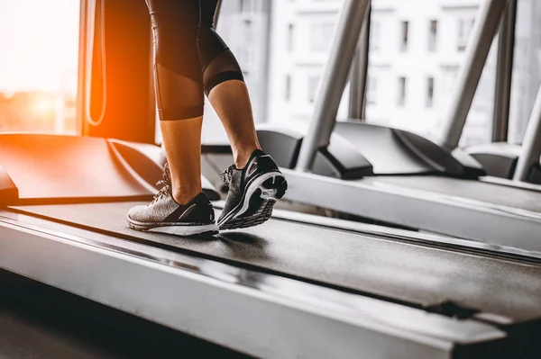 Ayakkabıya yakın çekim, spor salonunda koşu yapan kadınlar. Konsept egzersizi. Spor ve sağlıklı yaşam tarzı. 