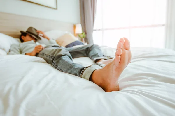 幸せな旅行者の男は白いベッドの上でリラックス 旅行休暇のコンセプト — ストック写真