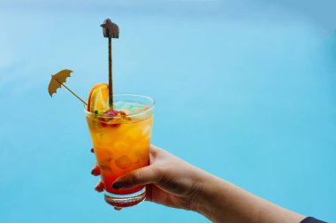 Kadın yüzme havuzunda kokteyl tutuyor. Belize 'de taze tropikal meyve suyu kokteyli servis ediliyor..