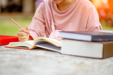 Not defterlerine yazan kitaplarla öğrencilerin ellerini kapat. Eğitim ve okul konsepti