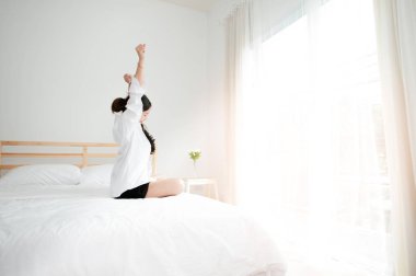 Uyandıktan sonra yatakta uzanan bir kadın.