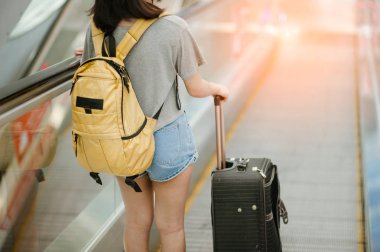 Genç bir kadın modern havaalanı terminalinde akıllı telefon valizini çekiyor ve kullanıyor. Taşıyıcıyı beklerken bavuluyla gezen adam. Dikiz aynası. Boşluğu kopyala