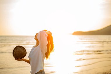 Kumsalda Güzel Günbatımının tadını çıkaran kadın