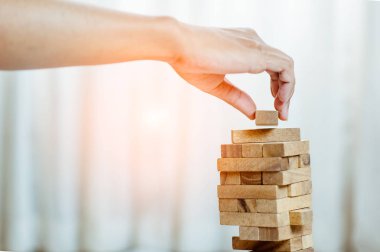 Modern ofisteki kuleye el çekmek ya da tahta bloğu yerleştirmek. Plan ve iş stratejisi. Arkaplan için bulanık.