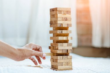 Modern ofisteki kuleye el çekmek ya da tahta bloğu yerleştirmek. Plan ve iş stratejisi. Arkaplan için bulanık.