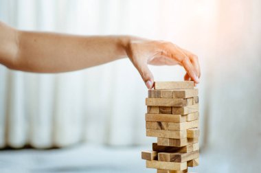 Modern ofisteki kuleye el çekmek ya da tahta bloğu yerleştirmek. Plan ve iş stratejisi. Arkaplan için bulanık.
