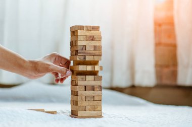 Modern ofisteki kuleye el çekmek ya da tahta bloğu yerleştirmek. Plan ve iş stratejisi. Arkaplan için bulanık.