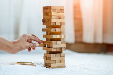 Modern ofisteki kuleye el çekmek ya da tahta bloğu yerleştirmek. Plan ve iş stratejisi. Arkaplan için bulanık.