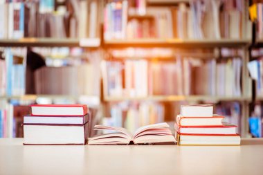 Kitap yığını kütüphane masasına konur. Eğitim geçmişi, okul kavramına dönüş.