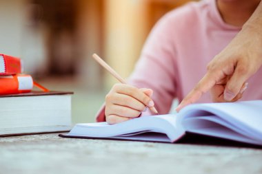 Genç öğrenci kampüsü, arkadaşının öğrenmesine yardımcı olur. Halk, öğrenim, eğitim ve okul kavramı