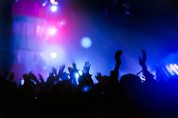 コンサートの手のシルエット 舞台からの光 人の群衆が手でシルエット リボン — ストック写真