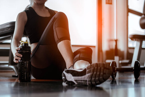 Relaxing after training.beautiful young woman looking away while sitting  at gym.young female at gym taking a break from workout.