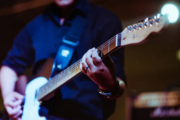 man playing guitar on a stage musical concert close-up view.guitarist plays.