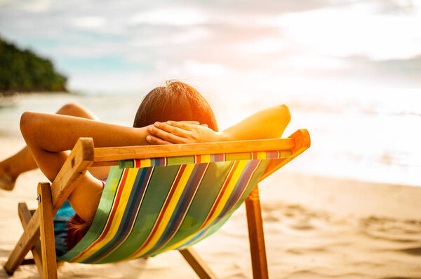 Женщина отдыхает на пляже, глядя на море. Копировальное пространство.