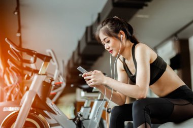 Spor salonunda müzik dinleyen fitness kadınının portresi. Egzersiz konsepti. Fitness ve sağlıklı yaşam tarzı. 
