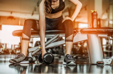 Vücut geliştirici, spor salonundaki halter ağırlıklarıyla çalışıyor. Halterle egzersiz yapıyor. Fitness kaslı vücut 