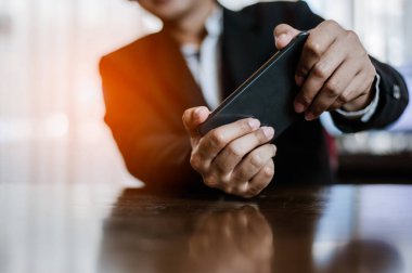 Molada akıllı telefonunda video oyunları oynayan bir işadamı.