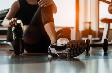 Eğitimden sonra dinleniyorum. Spor salonunda otururken gözlerini kaçıran güzel bir genç kadın. Spor yapmaya ara veren genç bir bayan..