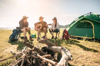 Bir grup genç, kamp gezisinde davul ve gitar çalmaktan zevk alıyor..