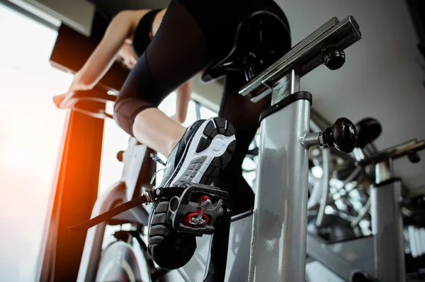 Spor salonunda egzersiz bisikletine binen fitness kadını. Egzersiz konsepti. Fitness ve sağlıklı yaşam tarzı. 