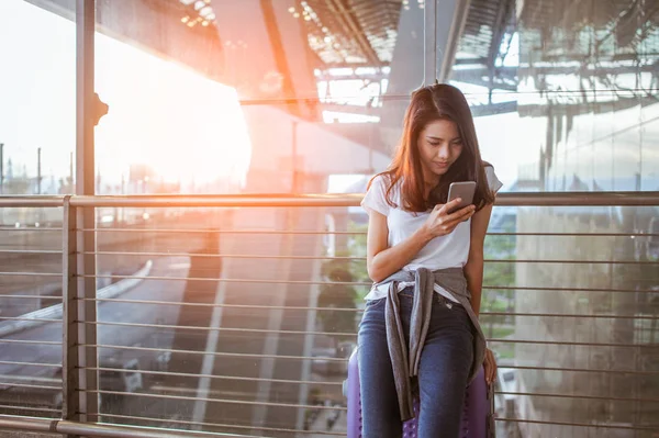 女性正在使用她们的智能手机在机场进行飞行检查 机场和技术概念 — 图库照片