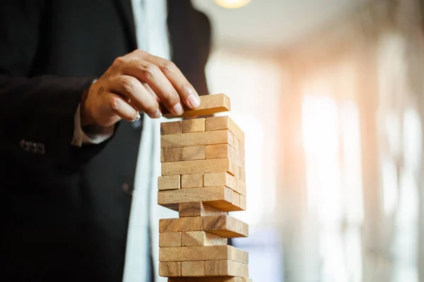 Uomo Affari Mano Tirando Fuori Mettendo Blocco Legno Sulla Torre — Foto Stock