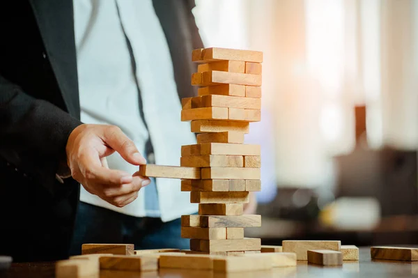 Uomo Affari Mano Tirando Fuori Mettendo Blocco Legno Sulla Torre — Foto Stock