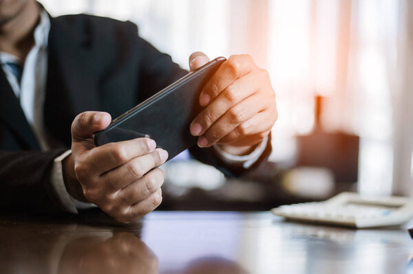 Businessman plying Video Games on his Smartphone During breaks.