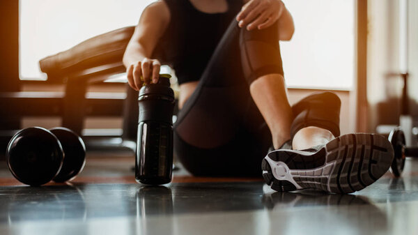 Relaxing after training.beautiful young woman looking away while sitting  at gym.young female at gym taking a break from workout.