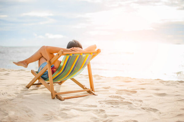 Женщина отдыхает на пляже, глядя на море. Копировальное пространство.