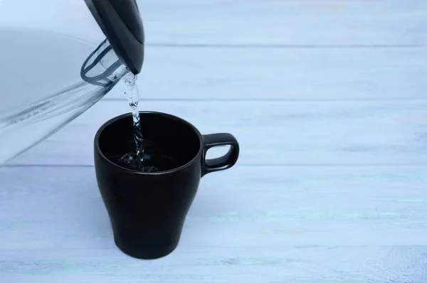 Taza Negra Está Llena Agua Una Tetera Vidrio Sobre Fondo —  Fotos de Stock