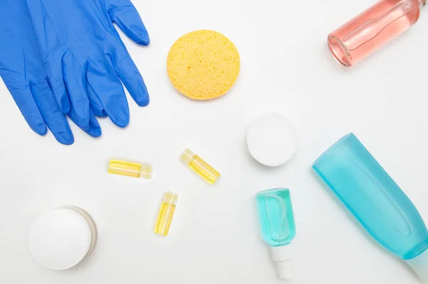 White table cosmetologist with cosmetic preparations and blue protective gloves.