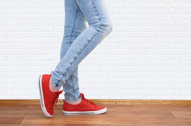 Kadın gençlik kitap. Kot pantolon ve spor ayakkabılar bacaklar.