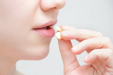 Kız onun elinde, açık ağız bir hap ile. Yakın çekim.