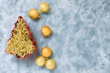 Noel süsleri. Altın toplar ve boncuk Noel ağacı için. Bir gri beton zemin üzerinde.